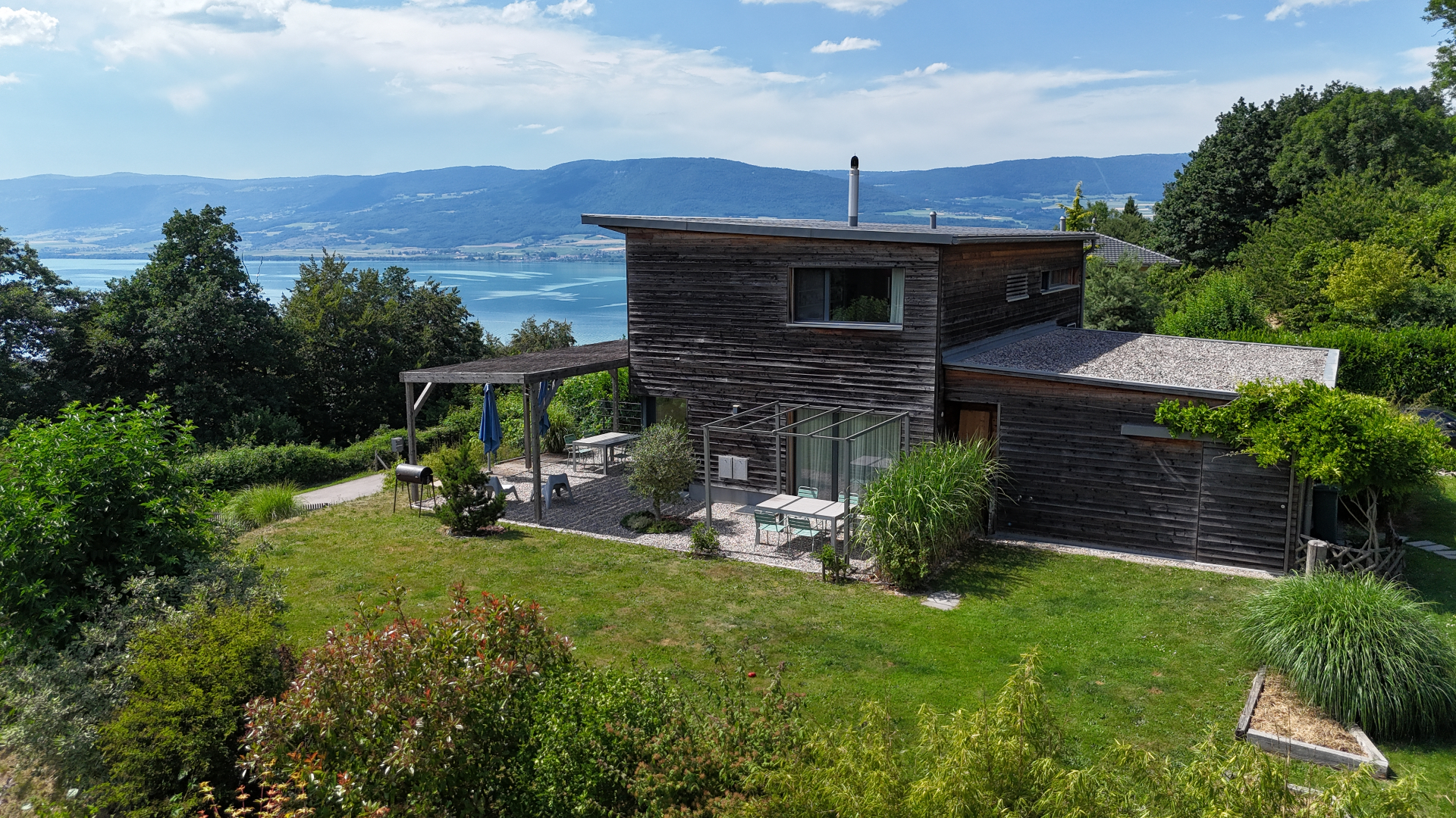 Villa d'architecte en bois avec appartement de rendement — vue lac de Neuchâtel, parcelle de 2'750 m² à Châbles.